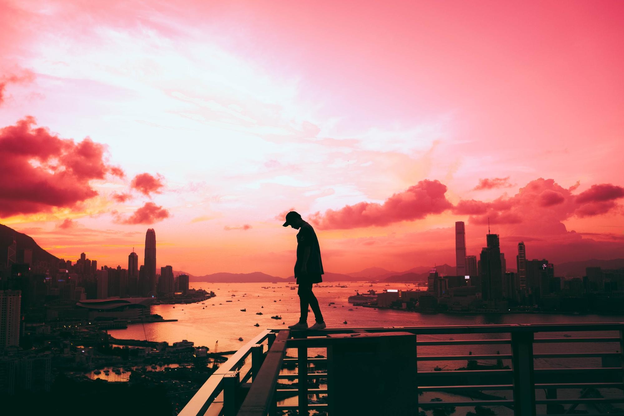 man walking on balcony rails