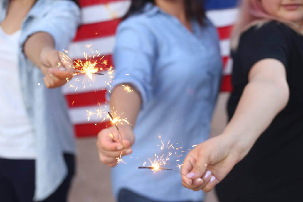 three women holding sparklers