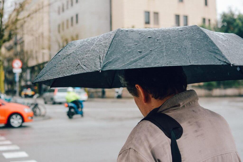 Man in business attire sheltering himself from the storm in the insurance newsletter